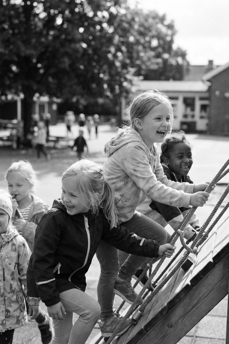 Barn i klätterställningen Barn klättrar i klätterställningen på skolans lekplats.